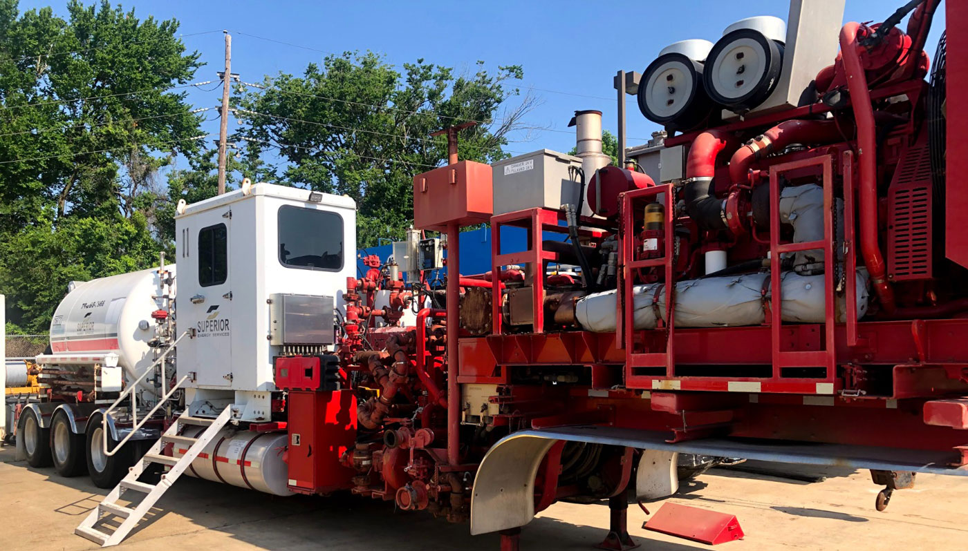 A red Superior Cementing foam cementing vehicle working on slurries